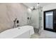 Modern bathroom featuring soaking tub, glass enclosed shower and marble style tile at 8316 E Glenrosa Ave, Scottsdale, AZ 85251