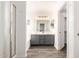 Bathroom with double sink vanity, large mirror, and walk-in shower with glass door at 8648 W Fargo Dr, Peoria, AZ 85382
