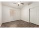 Bedroom features wood-look floors, ceiling fan, closet, and a window for natural light at 8648 W Fargo Dr, Peoria, AZ 85382