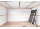 Spacious shed interior with plywood floor, white walls, and exposed beam ceiling at 8648 W Fargo Dr, Peoria, AZ 85382