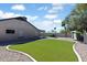 Spacious backyard featuring artificial turf lawn with desert landscaping at 905 E Bluefield Ave, Phoenix, AZ 85022