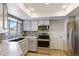 Bright kitchen features stainless steel appliances, stylish backsplash, and granite countertops at 905 E Bluefield Ave, Phoenix, AZ 85022