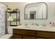 Bright bathroom featuring double sinks, large vanity mirror and shelf space at 1011 E Amberwood Dr, Phoenix, AZ 85048