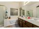 Bathroom features double sinks, a large tub under a glass block window, and a separate glass door shower at 1011 E Amberwood Dr, Phoenix, AZ 85048