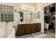 Well-lit bathroom with double vanity, tub, glass block window, and a closet with ample storage space at 1011 E Amberwood Dr, Phoenix, AZ 85048