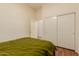 Small bedroom features a closet with sliding doors and cozy green bedding. Perfect for a guest room at 1011 E Amberwood Dr, Phoenix, AZ 85048