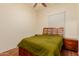 Cozy bedroom with wood floors, a bed with green bedding, and a nightstand on either side at 1011 E Amberwood Dr, Phoenix, AZ 85048