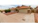 Wide driveway leading to a two-car garage with stone accents and a terracotta tile roof at 1011 E Amberwood Dr, Phoenix, AZ 85048