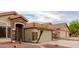 Home exterior with a two-car garage, stone accents, and desert landscaping at 1011 E Amberwood Dr, Phoenix, AZ 85048