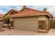 Two-car garage with stone accents and a terracotta tile roof at 1011 E Amberwood Dr, Phoenix, AZ 85048
