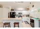 Bright kitchen with white cabinets, a black refrigerator, and an island with barstool seating at 1011 E Amberwood Dr, Phoenix, AZ 85048