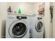 Laundry room features modern washer and dryer with shelves for storage at 1011 E Amberwood Dr, Phoenix, AZ 85048