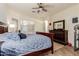 Comfortable main bedroom featuring a ceiling fan, dresser, and lots of natural light from the windows at 1011 E Amberwood Dr, Phoenix, AZ 85048