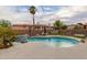 Backyard pool with rock waterfall features, palm trees and pebble accents at 1011 E Amberwood Dr, Phoenix, AZ 85048