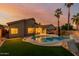 Backyard pool with tropical landscaping and outdoor seating area at 1011 E Amberwood Dr, Phoenix, AZ 85048