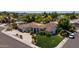 Expansive desert home featuring a tile roof, lush landscaping, circular driveway, and multi-car garage at 10205 E Corrine Dr, Scottsdale, AZ 85260