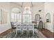 Elegant dining room with a large table, chandelier, hardwood floors, and stylish shuttered windows at 10205 E Corrine Dr, Scottsdale, AZ 85260