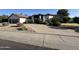 Exterior shot of a single-Gathering home with lush landscaping, front yard, and curved driveway at 10205 E Corrine Dr, Scottsdale, AZ 85260