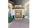 Inviting front entry with double doors, tile roof, decorative wreath, and mature landscaping at 10205 E Corrine Dr, Scottsdale, AZ 85260