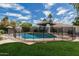 Sparkling swimming pool surrounded by a safety fence and lush landscaping, ideal for outdoor enjoyment at 10205 E Corrine Dr, Scottsdale, AZ 85260