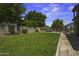 Lush backyard with well-maintained grass, mature trees, and manicured planter beds at 112 E Joseph Way, Gilbert, AZ 85295