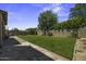 A beautiful backyard featuring green grass, a small tree, and a stone patio at 112 E Joseph Way, Gilbert, AZ 85295