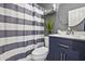 Charming bathroom features a blue vanity, striped shower curtain, and modern fixtures for a fresh and clean look at 112 E Joseph Way, Gilbert, AZ 85295