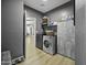 Functional laundry room features gray cabinetry and shelving with washer and dryer hookups, with a door leading to another room at 112 E Joseph Way, Gilbert, AZ 85295