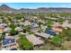 Aerial image showcasing a community with mature trees and solar panels against a mountain backdrop at 12727 W Lowden Rd, Peoria, AZ 85383