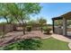 An idyllic backyard featuring lush artificial turf and an outdoor kitchen under a covered patio at 12727 W Lowden Rd, Peoria, AZ 85383