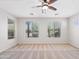Bright bedroom with neutral carpet, ceiling fan, and multiple windows offering views of the surrounding landscape at 12727 W Lowden Rd, Peoria, AZ 85383