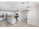 Open kitchen features island, stainless appliances, white cabinetry and granite countertops at 12727 W Lowden Rd, Peoria, AZ 85383