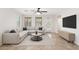 Staged living room with tile flooring, gray sectional sofa, rug, and a television at 12727 W Lowden Rd, Peoria, AZ 85383