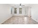 Empty living room with tile flooring, neutral paint, a ceiling fan, and a glass paneled door to the exterior at 12727 W Lowden Rd, Peoria, AZ 85383