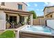 Inviting backyard with a relaxing hot tub, covered patio, outdoor seating, and lush landscaping at 13088 N 91St Dr, Peoria, AZ 85381