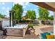 Relaxing backyard with a hot tub, patio area, well-manicured plants and trees, and rock landscaping at 13088 N 91St Dr, Peoria, AZ 85381