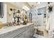 Elegant bathroom featuring dual sinks, granite countertops, decorative mirrors and stylish fixtures at 13088 N 91St Dr, Peoria, AZ 85381