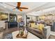 The inviting living room seamlessly connects to the open kitchen and dining area, perfect for modern living at 13088 N 91St Dr, Peoria, AZ 85381