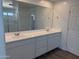 Bright bathroom with double sinks, white quartz countertop, walk-in shower, and tile floors at 13294 W Eagle Feather Rd, Peoria, AZ 85383