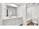 Bright bathroom with a double sink vanity, large mirror, and wood-look tile flooring at 13294 W Eagle Feather Rd, Peoria, AZ 85383