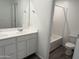 Bright bathroom showcasing double sinks with white cabinets and a shower-tub combo at 13294 W Eagle Feather Rd, Peoria, AZ 85383