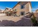 A backyard features a patio with comfortable seating and easy-care landscaping under a clear, blue sky at 13750 W Roanoke Ave, Goodyear, AZ 85395