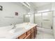 Bright bathroom with double sinks, wooden cabinets, and a separate tub and shower at 13750 W Roanoke Ave, Goodyear, AZ 85395