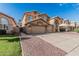 Two-story home featuring a three-car garage, neutral color scheme, grass, desert landscaping, and a concrete driveway at 13750 W Roanoke Ave, Goodyear, AZ 85395