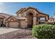 Two-story home featuring a three-car garage, neutral color scheme, mature landscaping, and a concrete driveway at 13750 W Roanoke Ave, Goodyear, AZ 85395