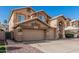 Two-story home featuring a three-car garage, neutral color scheme, desert landscaping, and a concrete driveway at 13750 W Roanoke Ave, Goodyear, AZ 85395