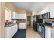 Modern kitchen with granite countertops, white cabinets, and stainless steel appliances at 16240 W Maricopa St, Goodyear, AZ 85338