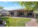 Well-maintained backyard featuring a lush lawn, gravel walkways, and an inviting covered patio at 18023 W Statler St, Surprise, AZ 85388