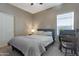 Cozy bedroom with a comfortable bed, natural light, and a convenient workspace with antique desk at 18023 W Statler St, Surprise, AZ 85388
