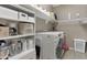 Functional laundry room with ample storage, modern appliances, and organized shelving for convenience at 18023 W Statler St, Surprise, AZ 85388